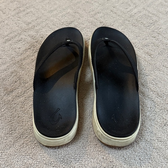 OluKai Nu'a Pi'o thong sandals in black synthetic material with a white sole - Picture 3 of 5